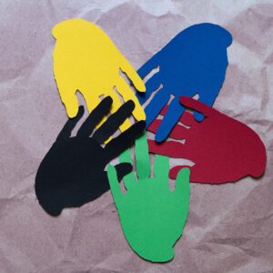 5 paper hands in 5 different colors imbricatedtogether