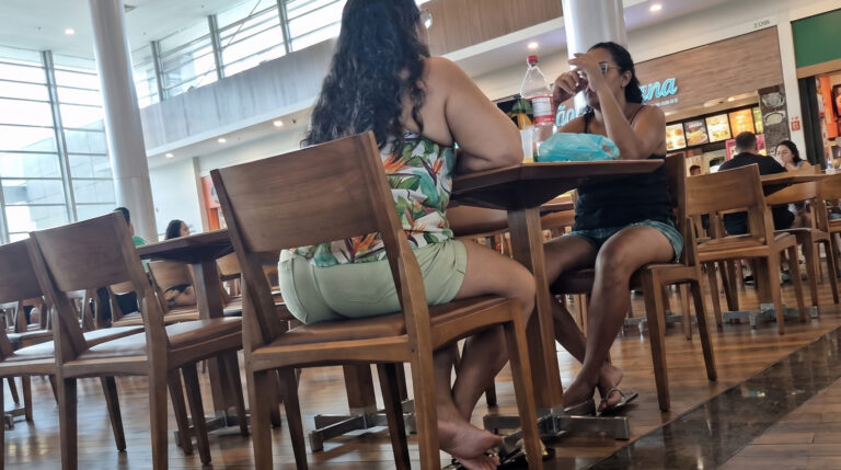 candid mature woman resting feet in shopping mall
