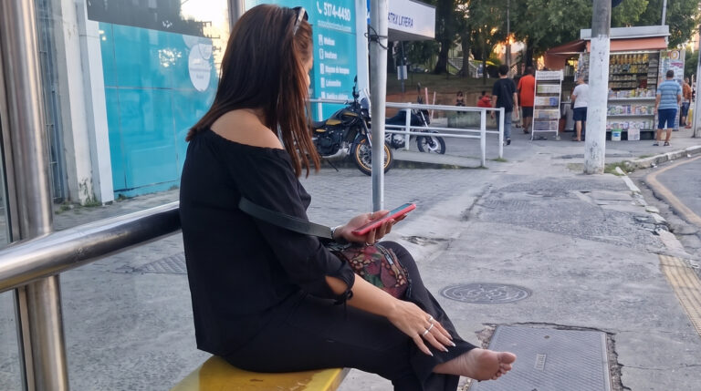 candid feet woman resting sweaty soles at bus stop